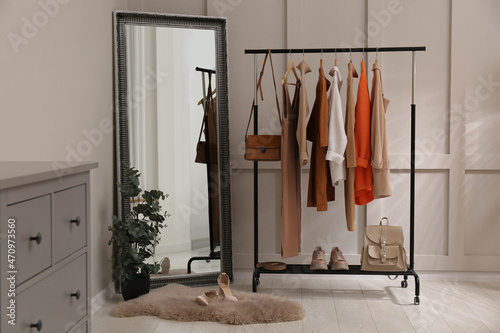 Rack with stylish women's clothes and mirror in dressing room © New Africa