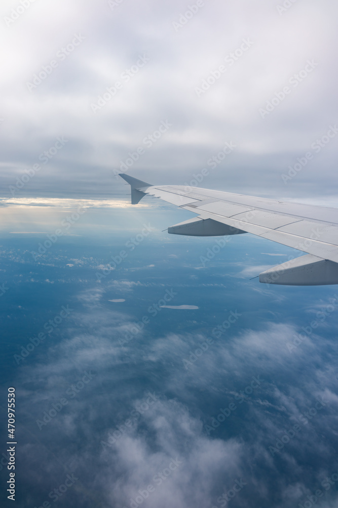 Fototapeta premium View from the airplane window at a beautiful blue sunrise and the airplane wing in clear sky.