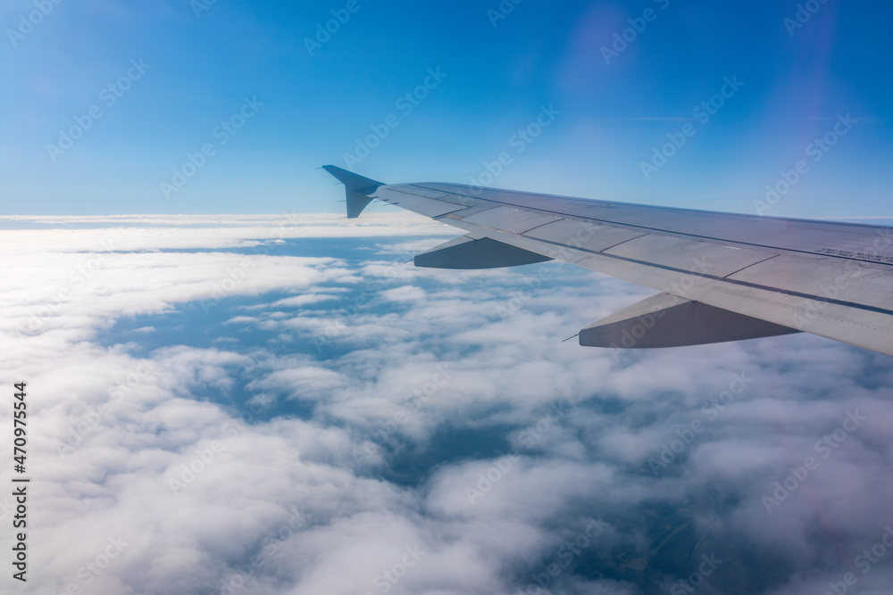 View from the airplane window at a beautiful cloudy sky and the airplane wing View from the airplane window at a beautiful cloudy sky and the airplane wing