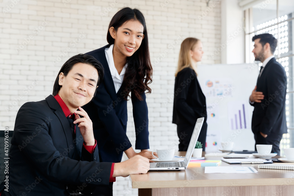 Cheerful Asian colleagues near business people Cheerful Asian colleagues near business people