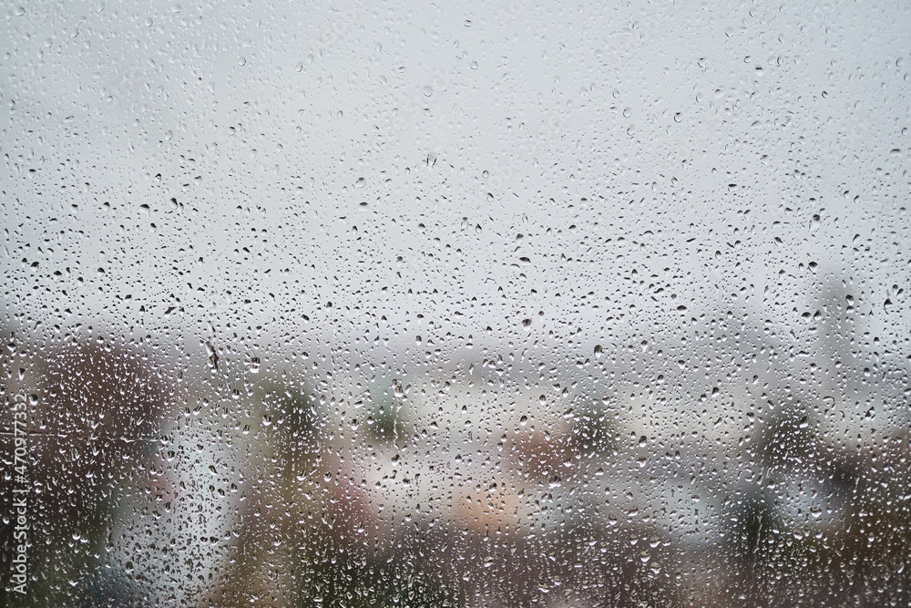 Raindrops on window and blurred urban background
