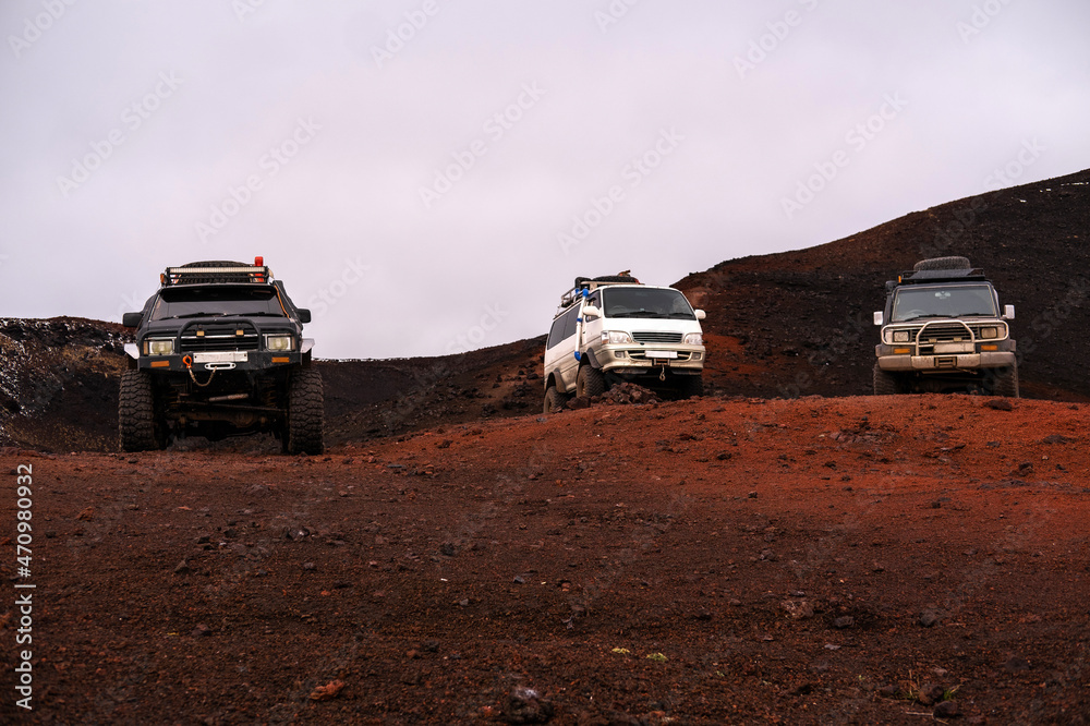 Off road car on volcano area. Solidified lava, red and black soil, volcanic slag