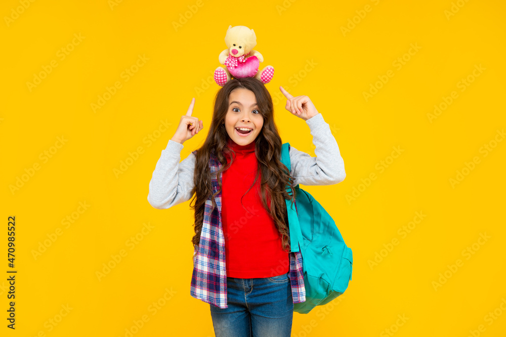 smiling teen girl in casual clothes holding school bag and toy bear on yellow background, school smiling teen girl in casual clothes holding school bag and toy bear on yellow background, school