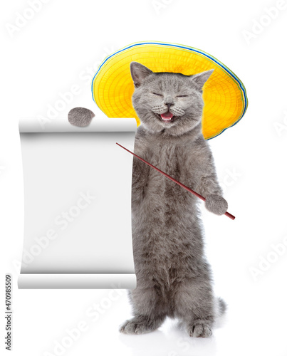 Happy cat wearing summer hat points on empty list. isolated on white background