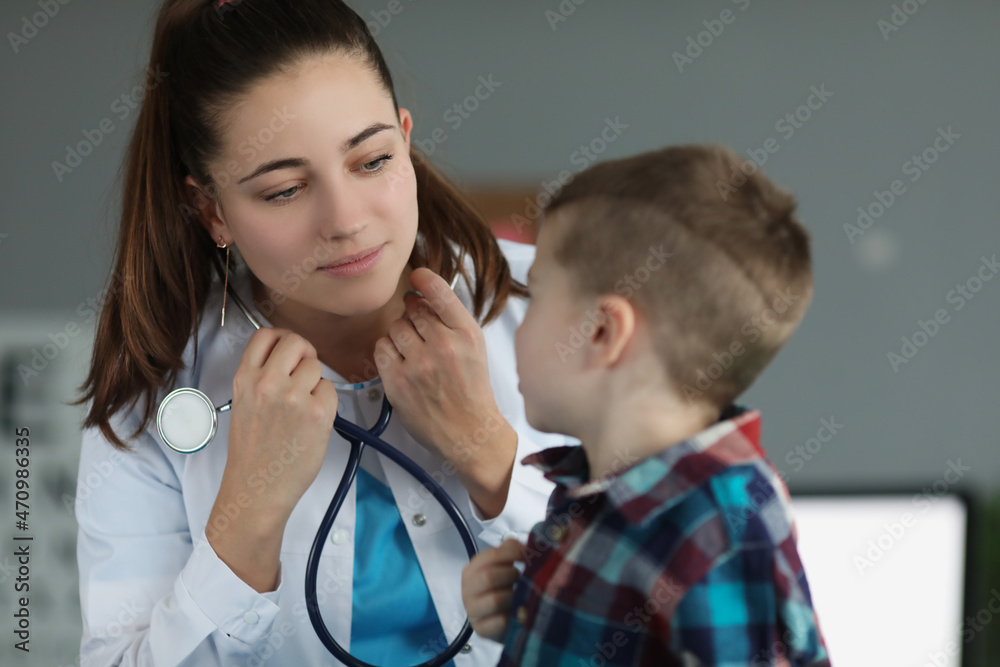 Little boy sitting on doctor appointment, qualified pediatrician wear stethoscope Little boy sitting on doctor appointment, qualified pediatrician wear stethoscope