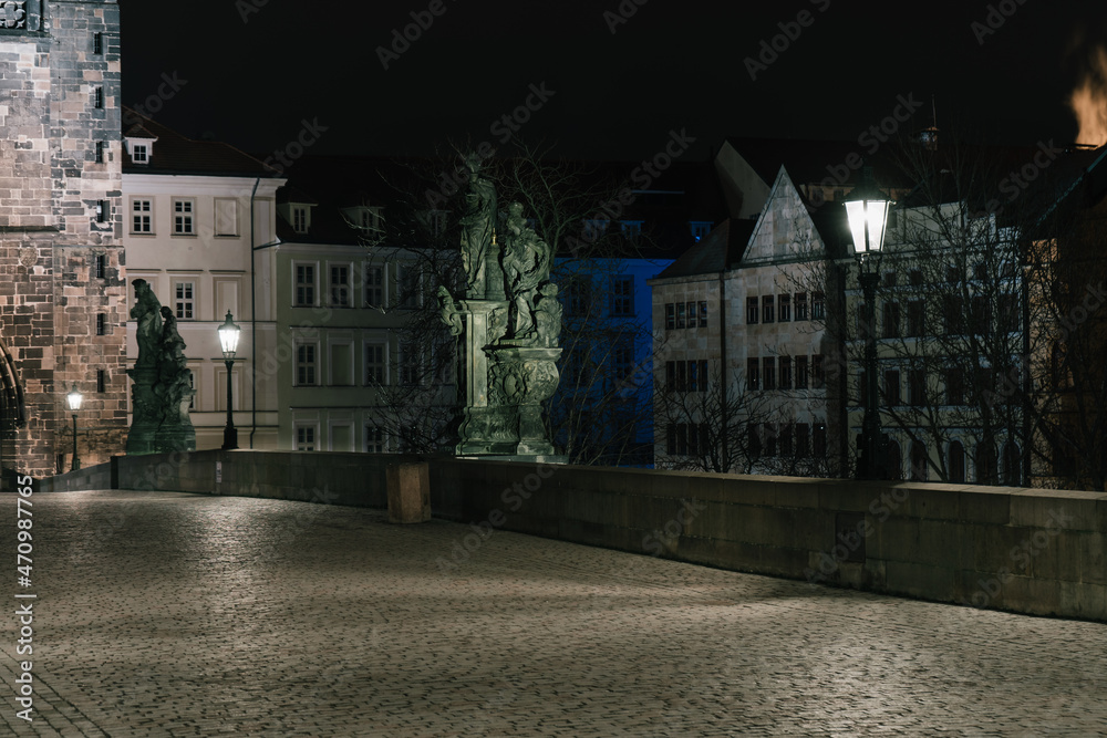 Obraz premium Street lights on the old stone Charles Bridge in the center of the city of Prague On the Vltava river at night and light from the street lights