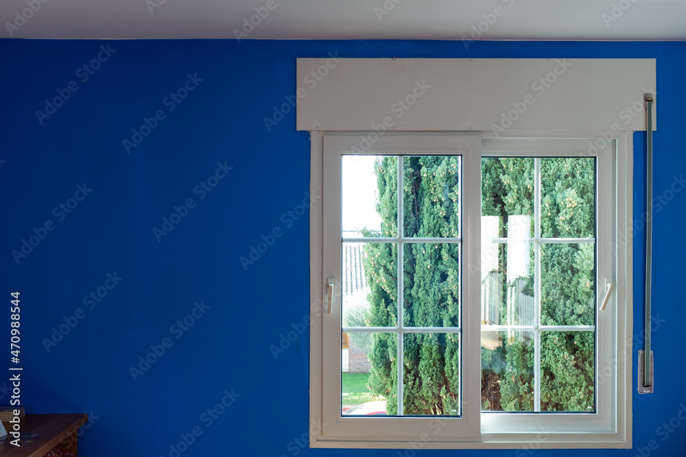 White modern window closed on a blue wall White modern window closed on a blue wall
