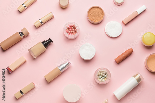 Different decorative cosmetics and clean cotton pads on pink background