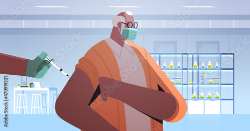 doctor hand vaccinating african american male patient in medical mask fight against coronavirus vaccine development