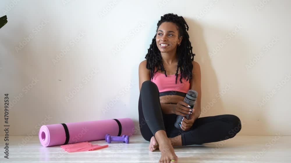 Young and fit woman sitting on the floor at home after intensive sport workout. Healthy lifestyle Young and fit woman sitting on the floor at home after intensive sport workout. Healthy lifestyle