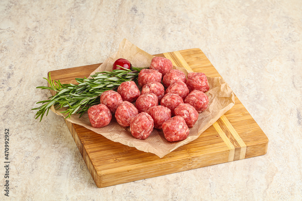 Raw uncooked beef meatballs served rosemary Raw uncooked beef meatballs served rosemary