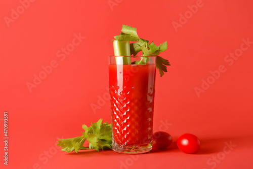 Glass of bloody mary with celery and tomatoes on color background © Pixel-Shot