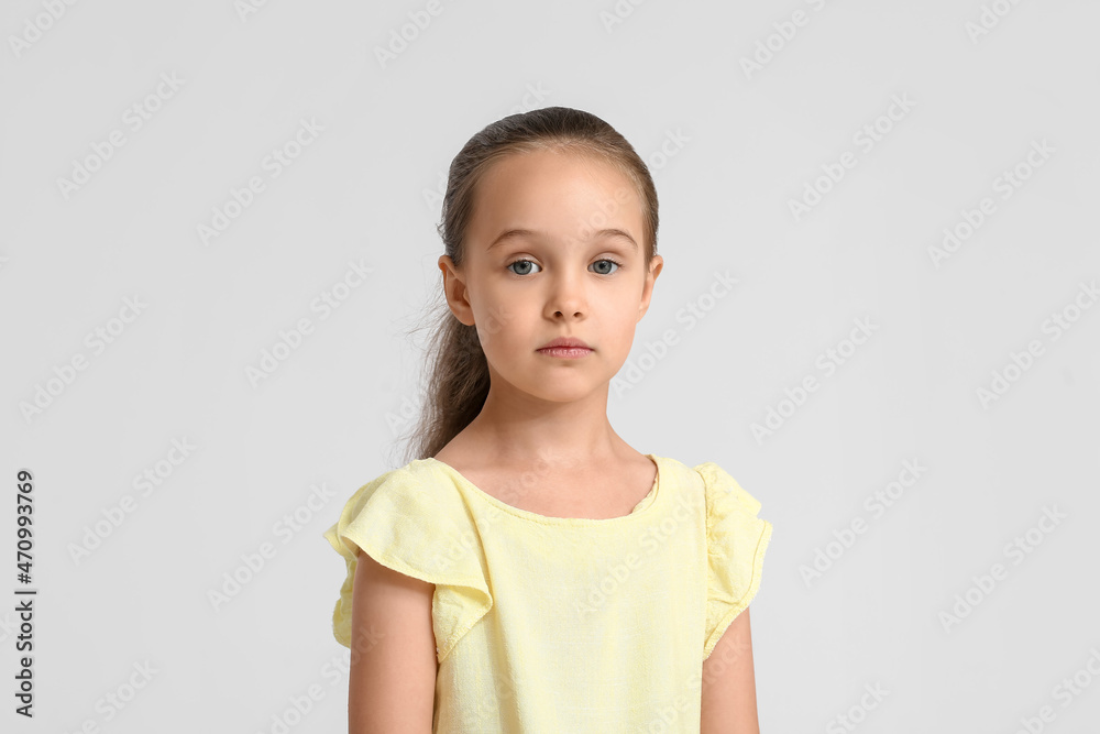 Portrait of cute little girl in yellow blouse on white background