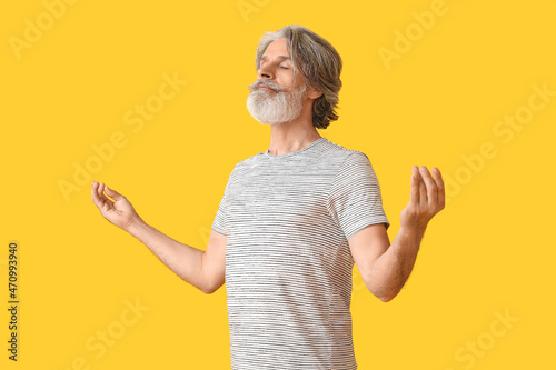 Meditating mature man on co...