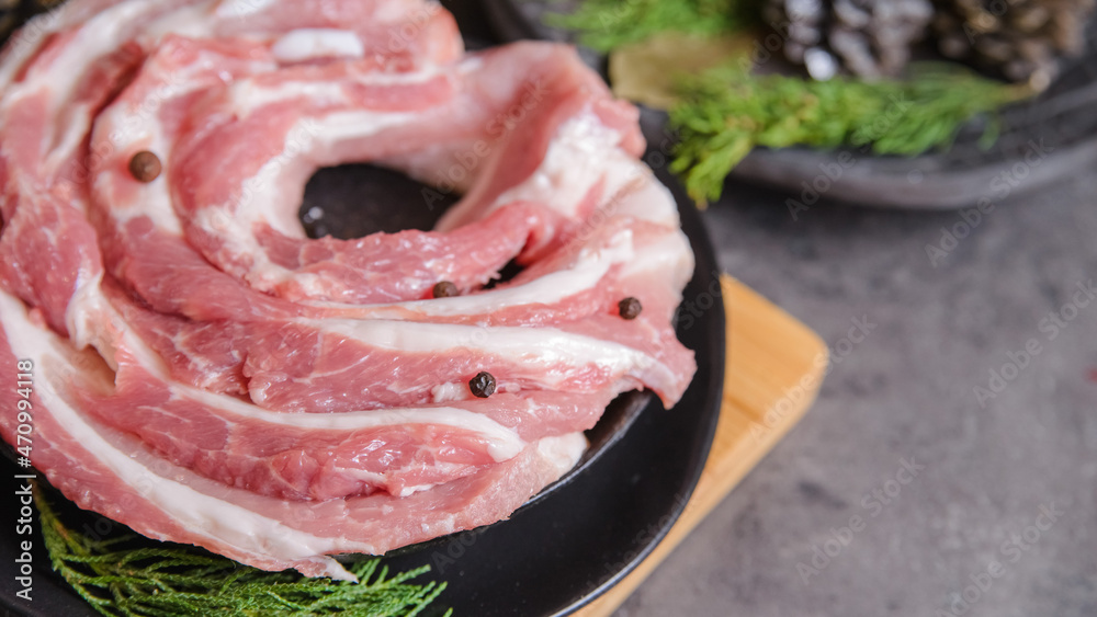 Raw bacon pork for preparing a dinner for a Christmas holiday dishes on a dark table with a Christmas decorations Raw bacon pork for preparing a dinner for a Christmas holiday dishes on a dark table with a Christmas decorations
