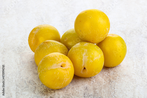 Ripe sweet yellow plum heap over background