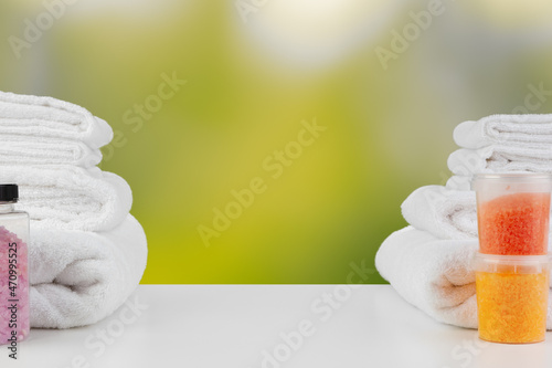 Various spa beauty threatment products and towels against blurred background photo