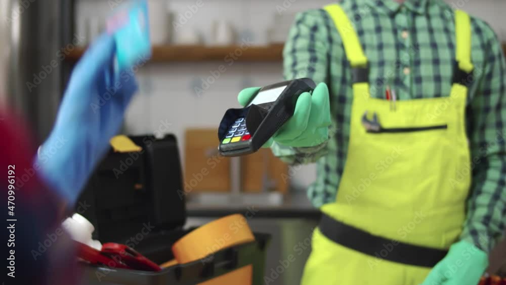 Cropped shot of woman in gloves playing plumber with credit card. Real time Cropped shot of woman in gloves playing plumber with credit card. Real time