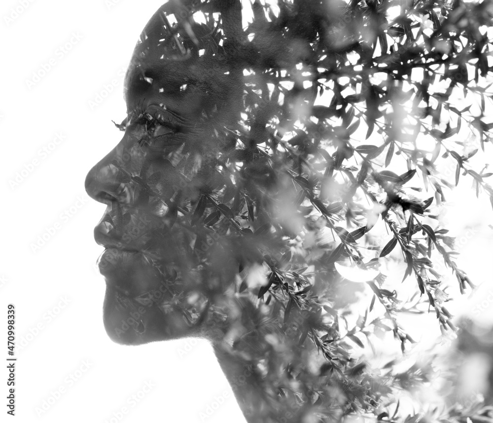A black and white portrait of a woman combined with nature in a double exposure technique.