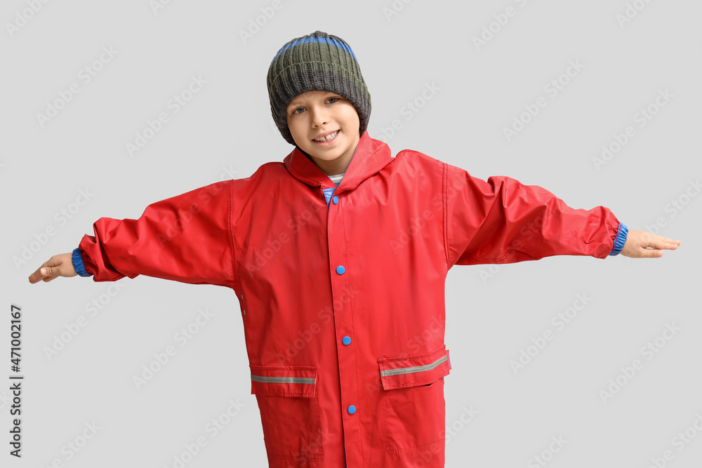Little boy in raincoat on light background Little boy in raincoat on light background