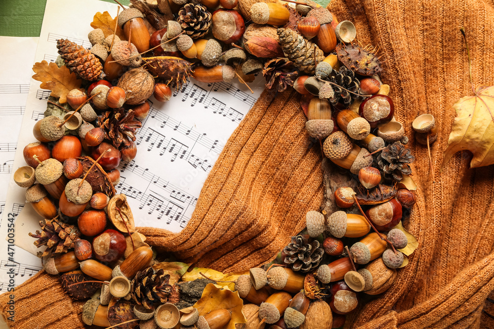Beautiful acorn wreath, sweater and notes on table - obrazy, fototapety, plakaty 