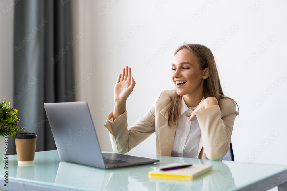 Beautiful freelancer woman talking in a video conference on line on laptop in an office desktop or home desk Beautiful freelancer woman talking in a video conference on line on laptop in an office desktop or home desk
