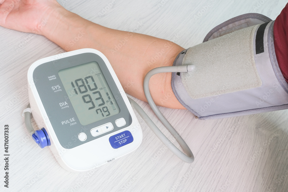 Man check blood pressure monitor and heart rate monitor with digital pressure gauge. Health care and Medical concept Man check blood pressure monitor and heart rate monitor with digital pressure gauge. Health care and Medical concept