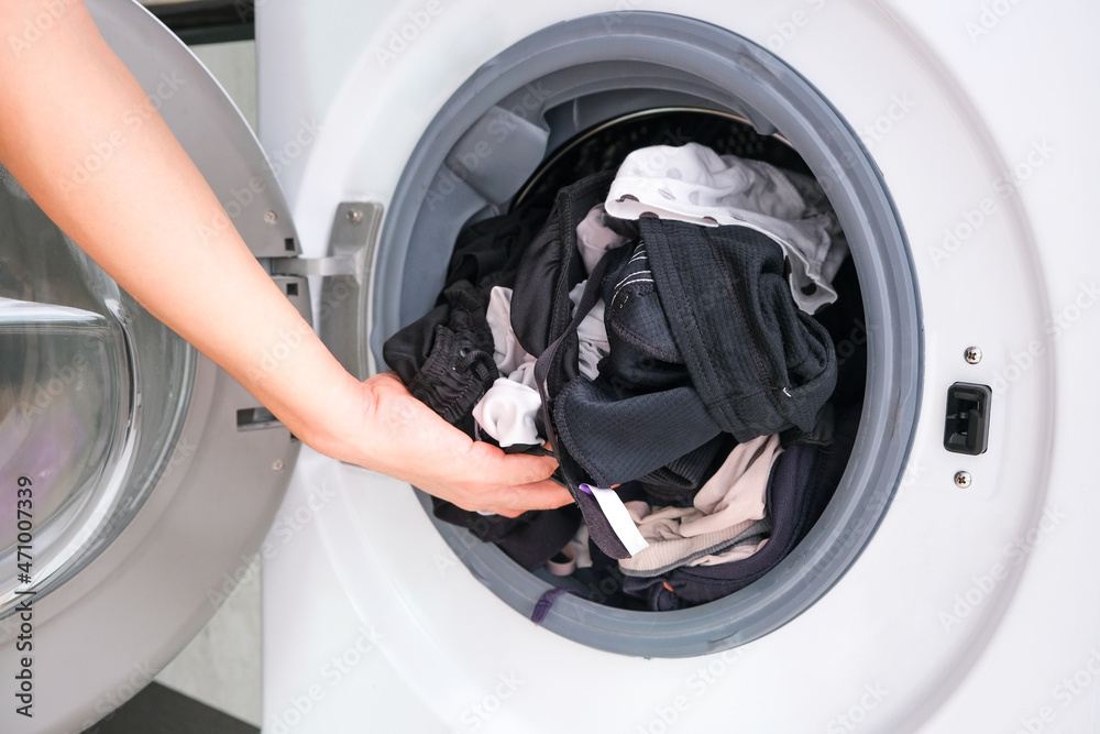 Woman's hand Pick up clothes Washing machine.Clean and Healthy Concepts. Woman's hand Pick up clothes Washing machine.Clean and Healthy Concepts.