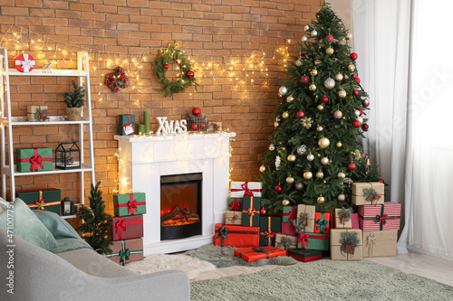 Beautiful living room with fireplace and fir tree with gifts on Christmas eve