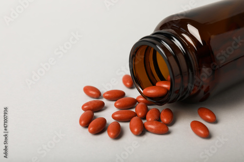 Bottle with pills on light background, closeup and space for text. Anemia treatment photo