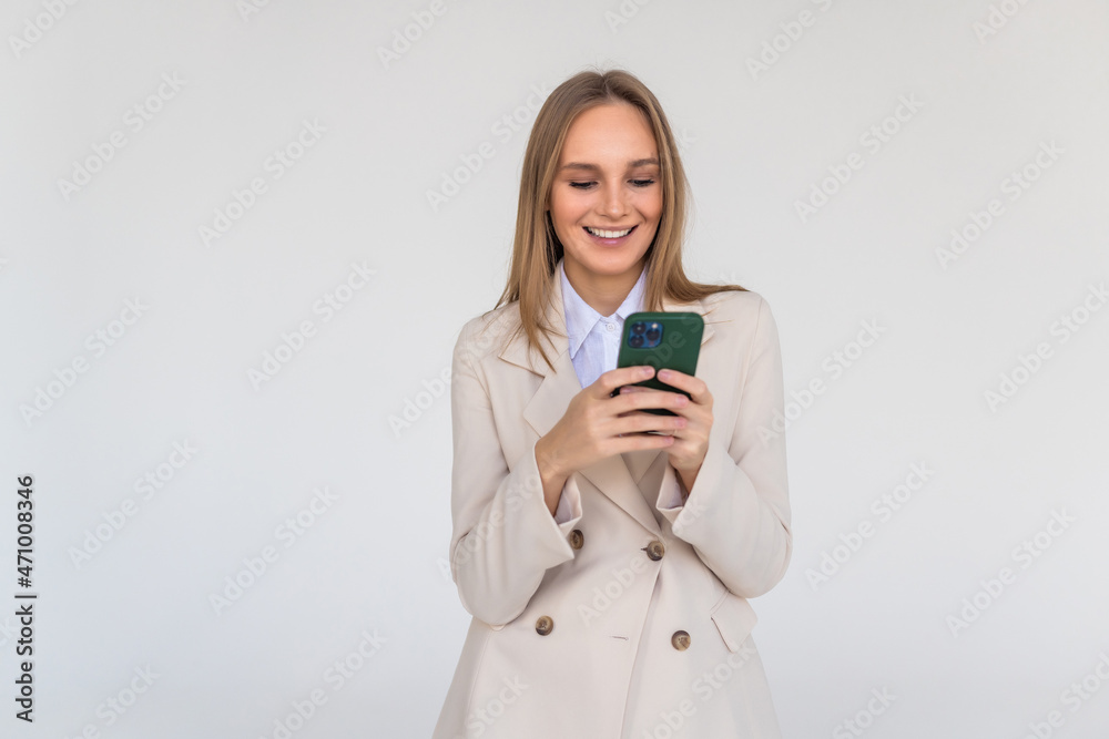 Young woman posing isolated over white wall background using mobile phone. Young woman posing isolated over white wall background using mobile phone.
