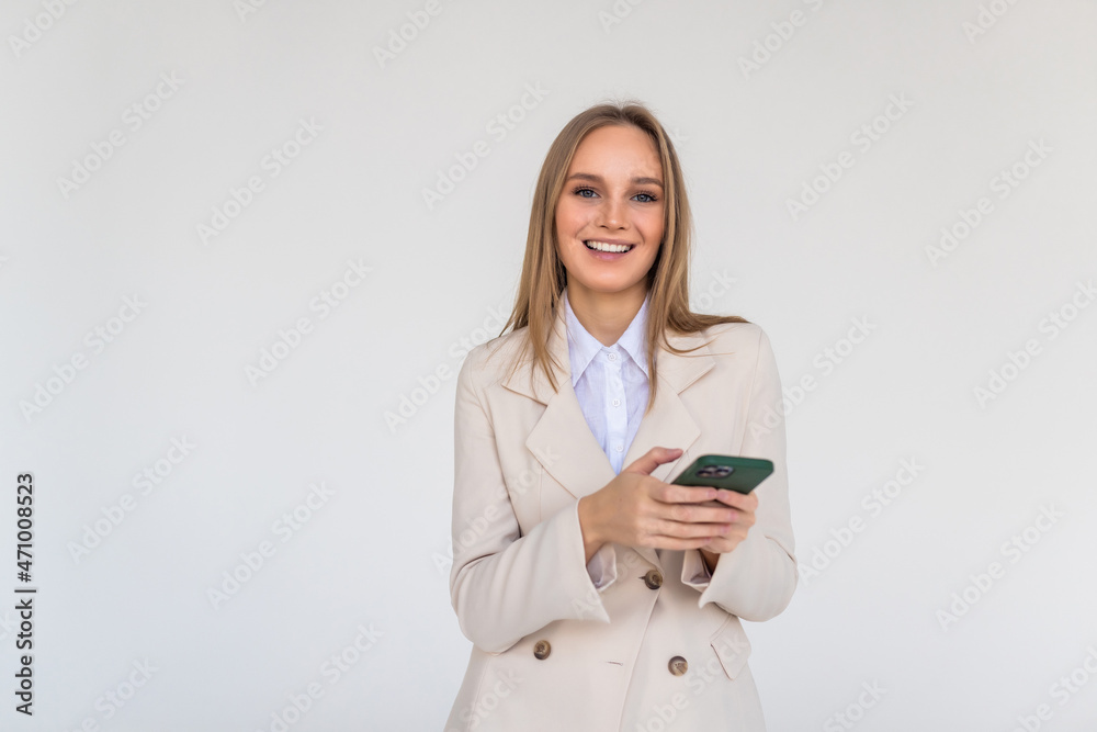 Young woman posing isolated over white wall background using mobile phone. Young woman posing isolated over white wall background using mobile phone.