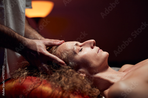 Woman on a massaging  chiropracting table  treatment of body and face skin tension.