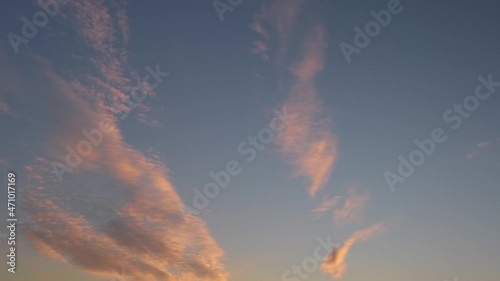 clouds floating slowly across the sky in the light of the setting sun.