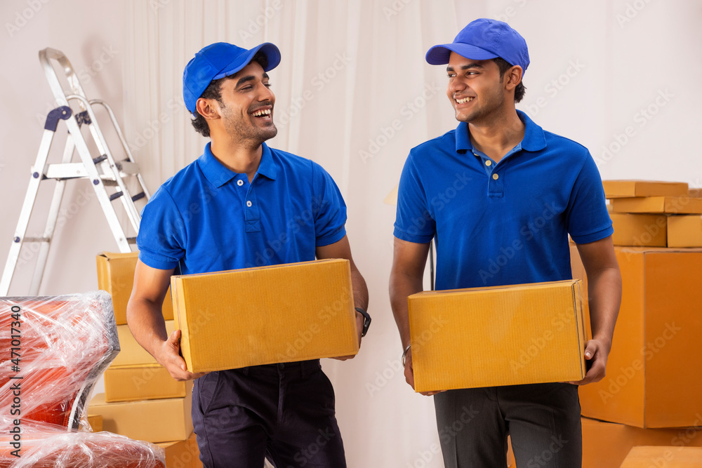Delivery boys in uniform standing with cardboard boxes Delivery boys in uniform standing with cardboard boxes