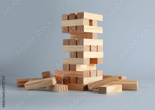 Jenga tower made of wooden blocks on grey background