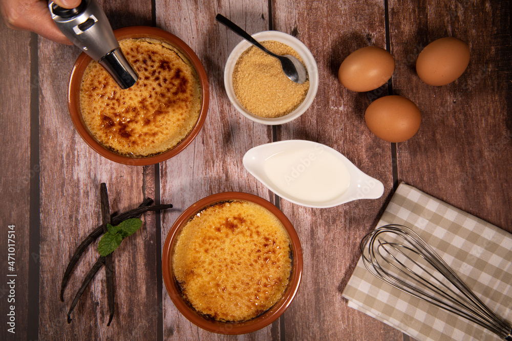 Chef cooks creme brulee with gas burner, dessert in the home kitchen, Cooking at home, professionals for food blog. High quality photo Chef cooks creme brulee with gas burner, dessert in the home kitchen, Cooking at home, professionals for food blog. High quality photo