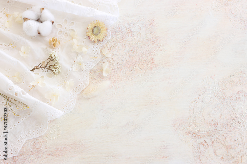 Background of white embroidered delicate lace fabric and dry flowers