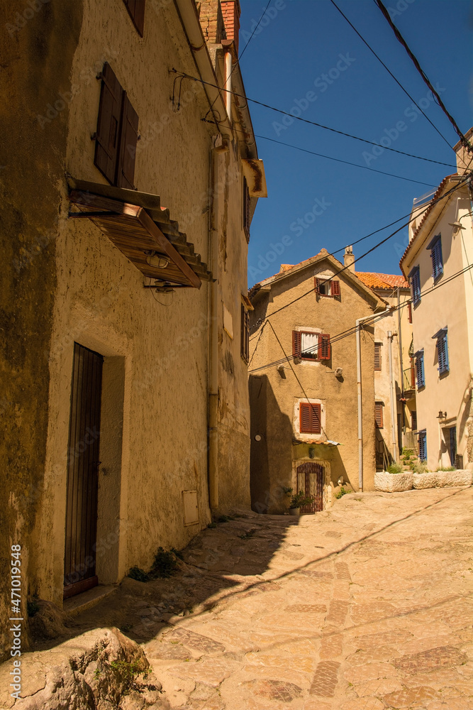 A quiet residential street in the historic medieval centre of Vrbnsk hill village on Krk Island in the Primorje-Gorski Kotar County of western Croatia
