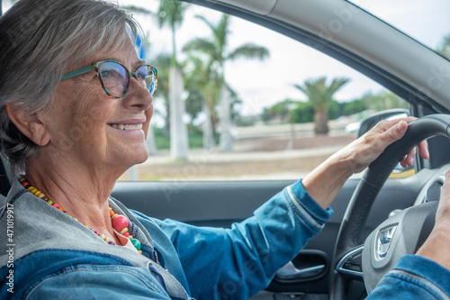Portrait of happy senior woman with eyeglasses driving car © luciano