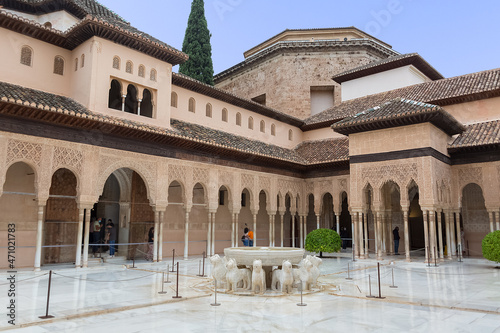 View at the exterior at the Patio at the Lions, twelve marble lions fountain on Palace of the Lions or Harem, Alhambra citadel, tourist people visiting photo
