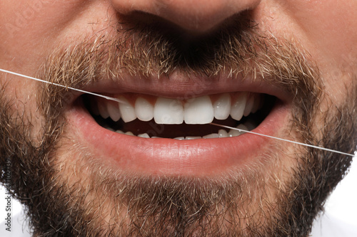 Man flossing his teeth  closeup. Dental care