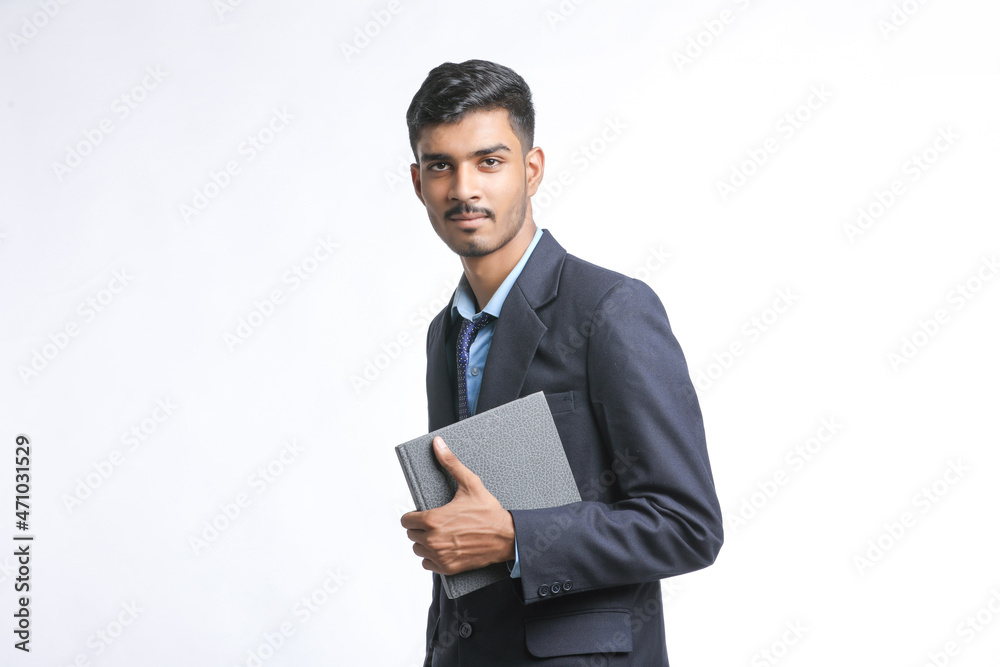 successful Young Indian businessman or employee wearing Suit and cheaking dairy on white background.
