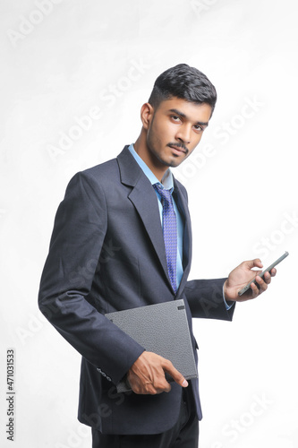 Young indian business man using smartphone on white background.