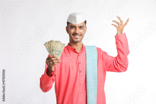 Young indian farmer showing money on white background. photo