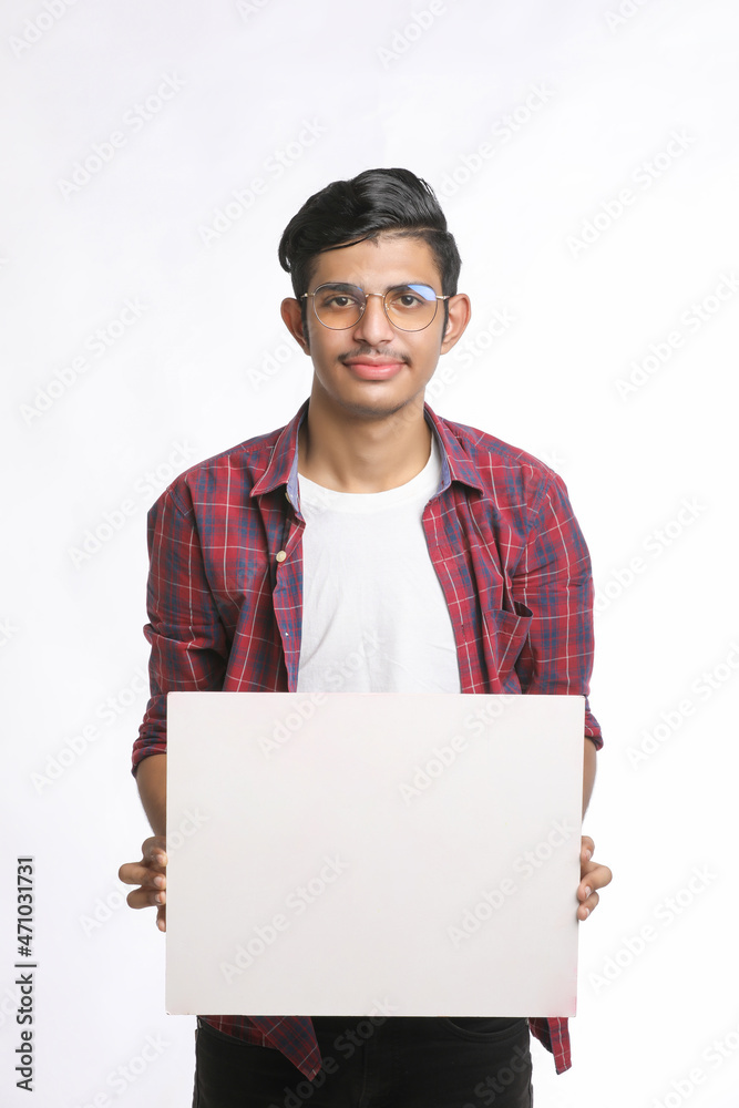 Young Indian man showing blank sing board over white background Young Indian man showing blank sing board over white background