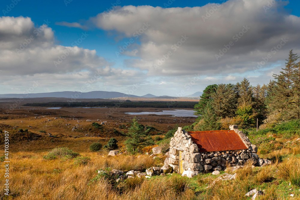Small stone building with rusty red metal roof with beautiful nature scenery in the background. Connemara area, county Galway, Ireland. Storage hut in a field. Historical building. Cloudy sky Small stone building with rusty red metal roof with beautiful nature scenery in the background. Connemara area, county Galway, Ireland. Storage hut in a field. Historical building. Cloudy sky