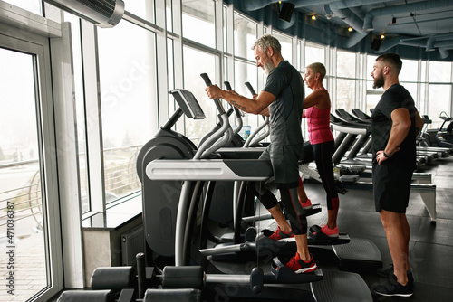 Active mature couple exercising together at gym
