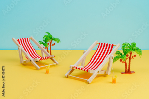 Sun loungers stand on a yellow background. Concept photo