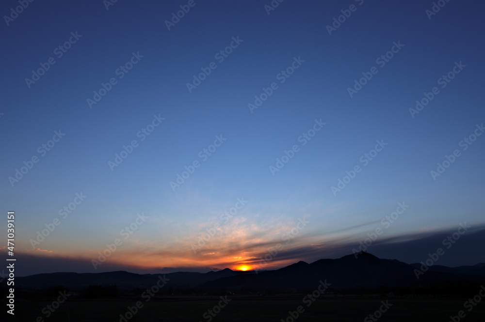 Fototapeta premium 濃い青に染まる夕陽の沈む空。